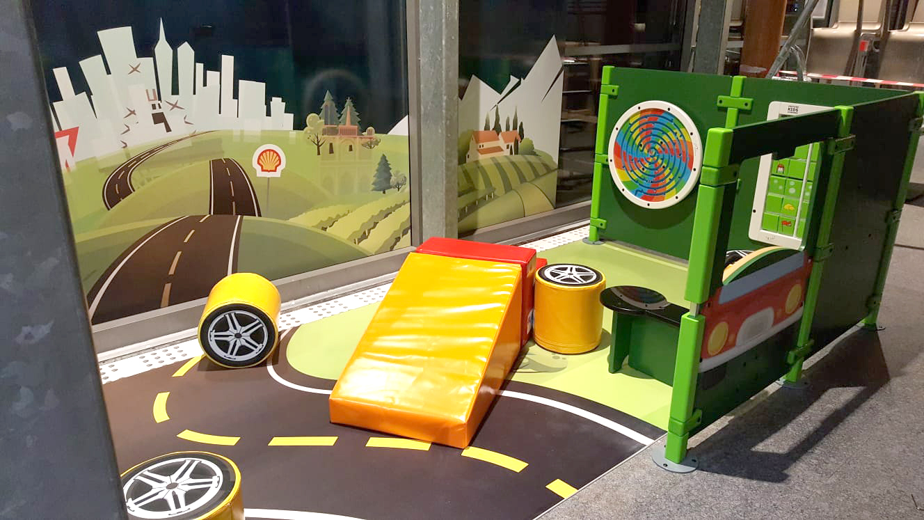 Rincón de juegos para niños en la gasolinera Shell de Francia con varios módulos de juego y juegos de pared